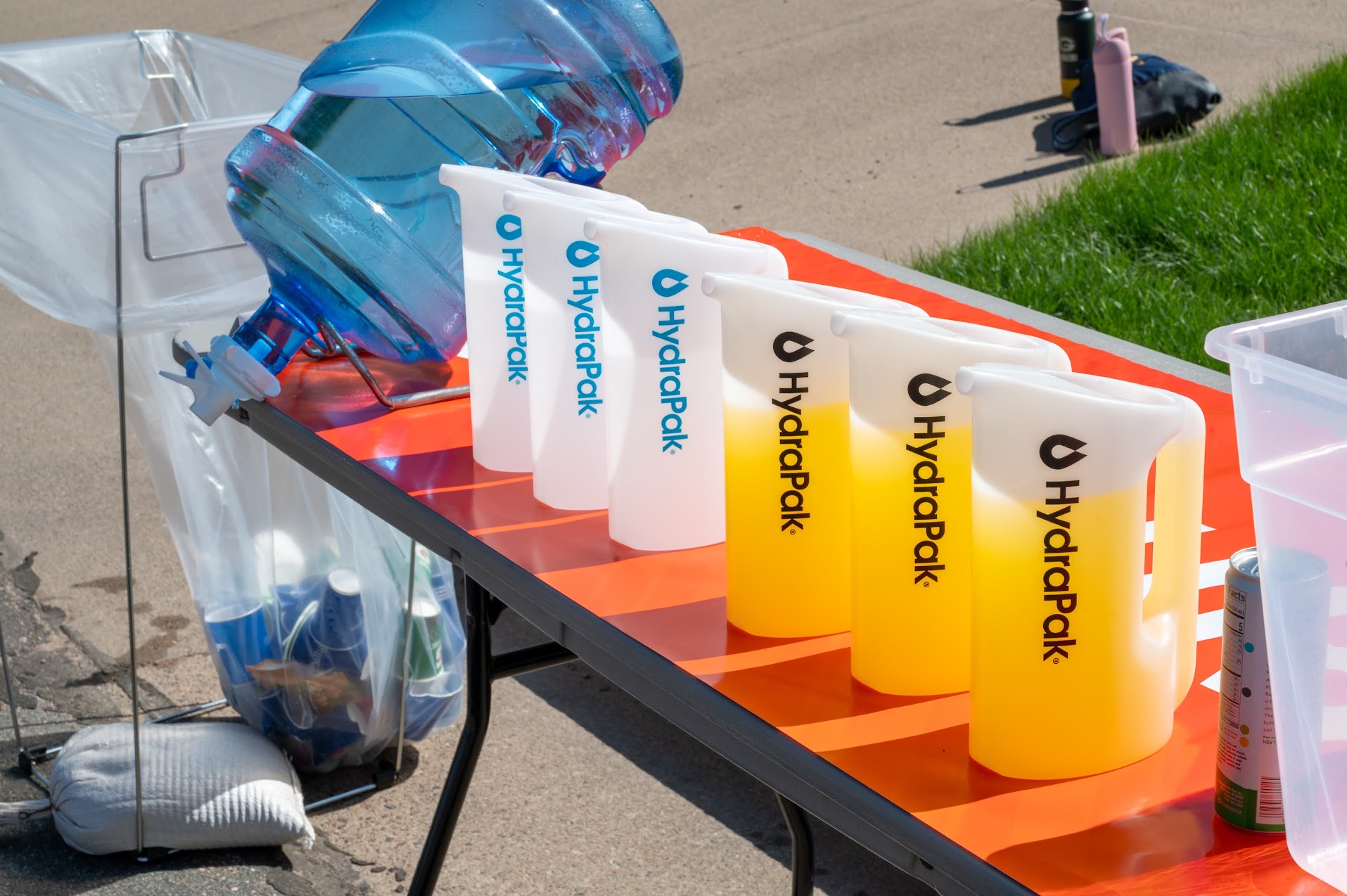 Reusable quick-fill pitchers at a race hydration station